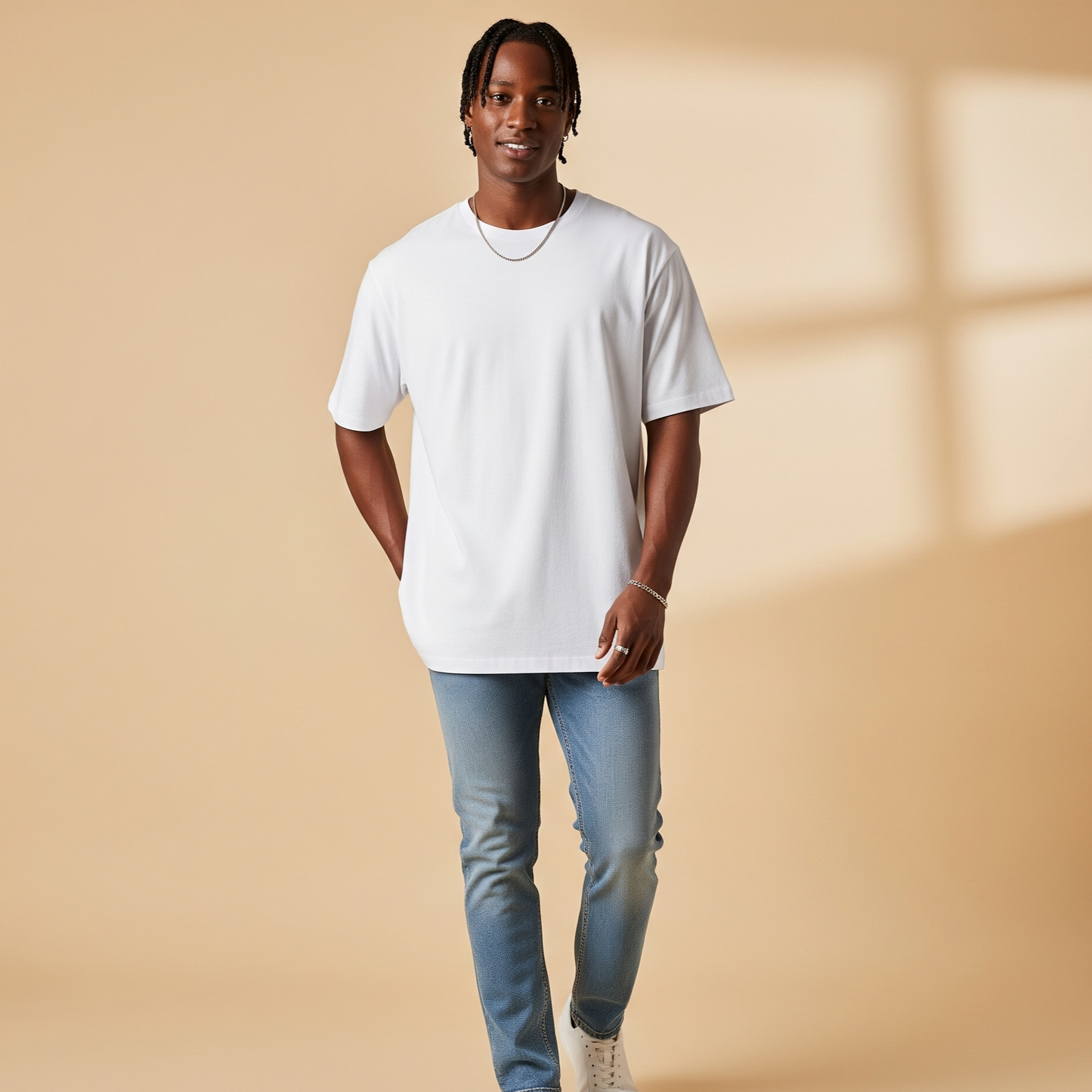 Man wearing a white t-shirt, blue jeans, and white sneakers on a beige background